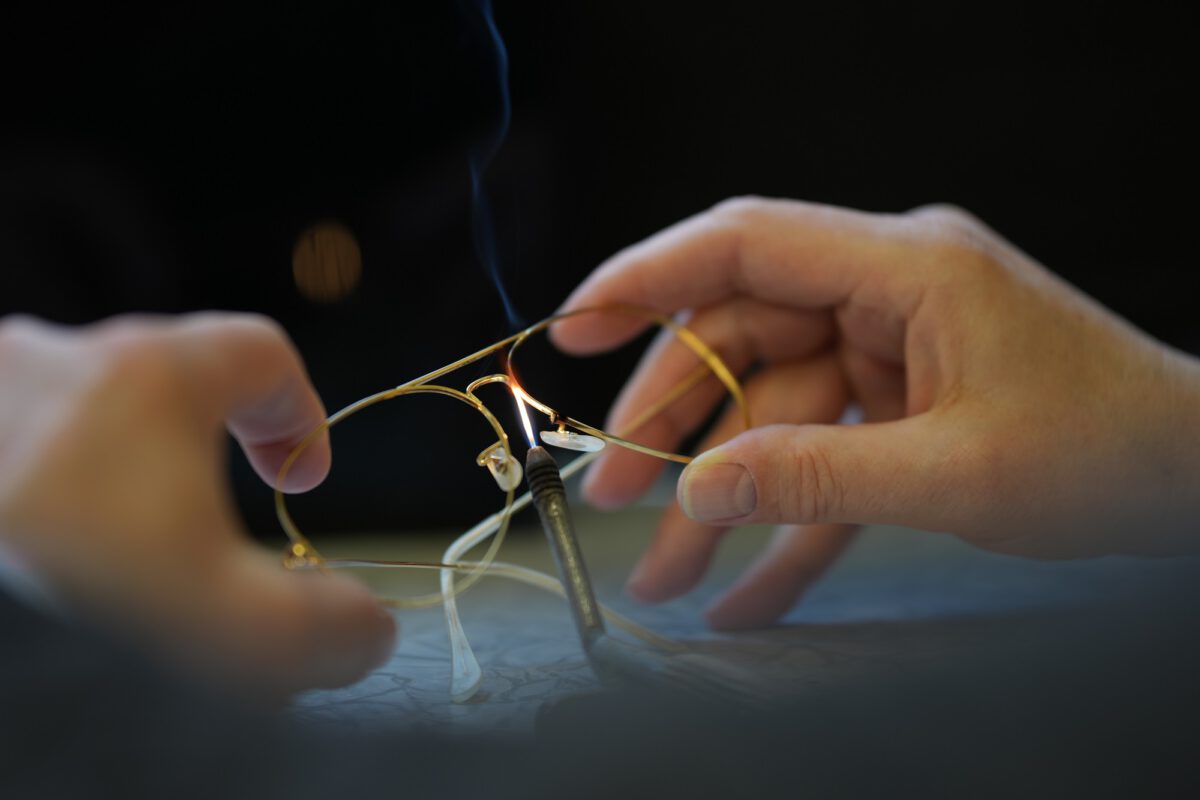 Brillenfassung in der Lötflamme bei einer Reparatur in der Werkstatt von Brillen Krille