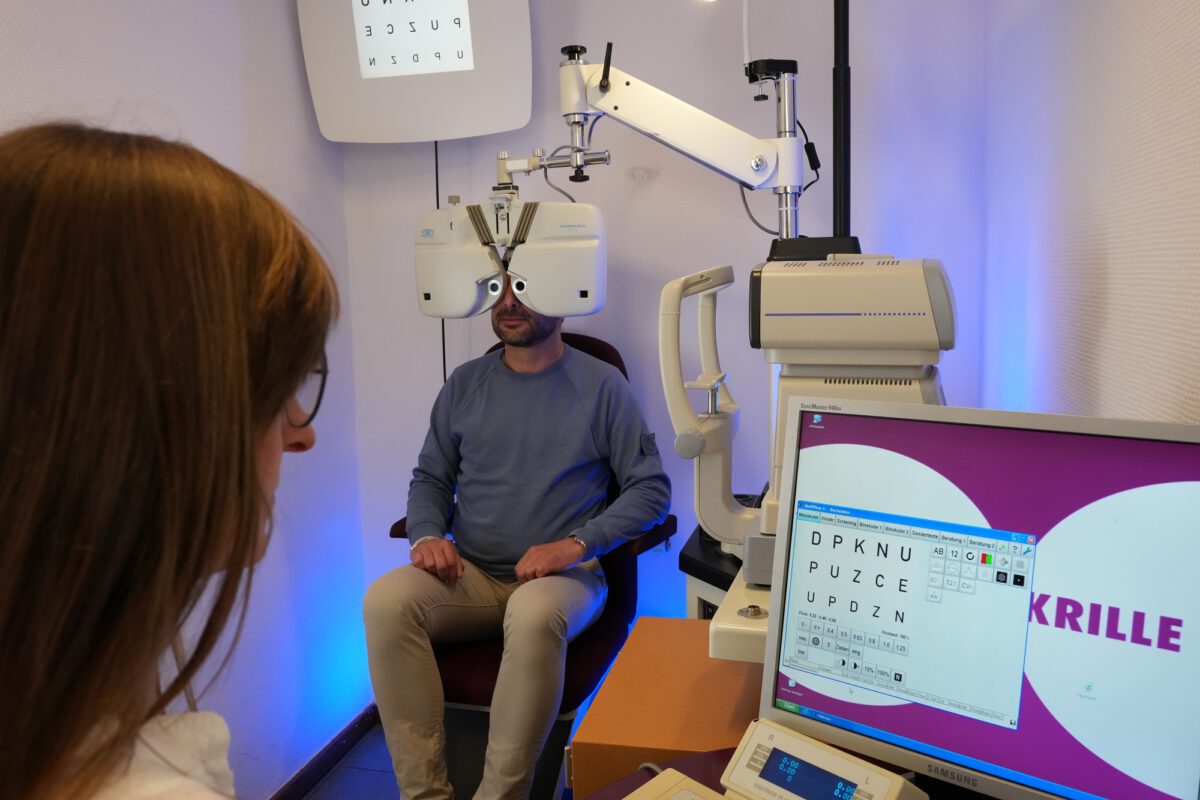 Augenoptikermeisterin bei der Sehbestimmung mit einem Kunden bei Brillen Krille in Rostock
